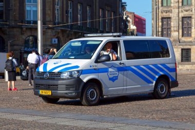 Amsterdam, Hollanda - 27 Ağustos 2017: Servis & Veiligheid 'den (Servis ve Güvenlik) iki GVB çalışanı, Dam Meydanı' nda minibüslerinde bekliyor.