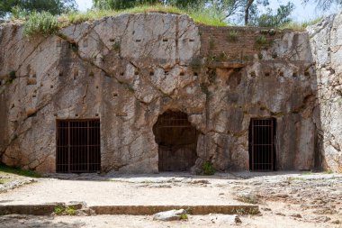 Atina 'daki Philapappos tepesinde geleneksel olarak Sokrates hapishanesi olarak kabul edilen ve zehirlendiği küçük bir dizi mağara bulunmaktadır. Bu doğru olabilir, ama tarih kesin değil..