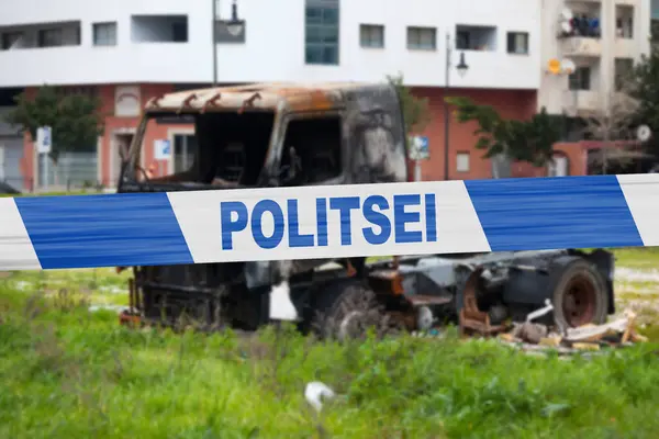Truck burnt by a pyromaniac with a police tape with written in it in Estonian \
