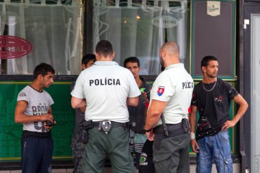 Bratislava, Slovakya - 18 Haziran 2018: Bratislava hl.st. 'deki dört yabancı uyruklu için kimliği kontrol eden iki Slovak polis memuru. tren istasyonu.