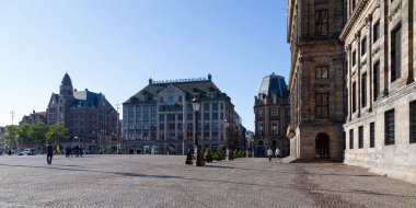 Amsterdam, Hollanda - 27 Ağustos 2017: Dam Meydanı 'nda Madam Tussauds ve Amsterdam Kraliyet Sarayı etrafında dolaşan turistler.