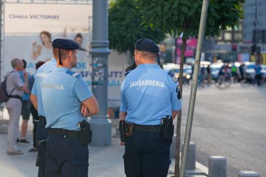 Bucharest, Romania - June 24 2018: Four officers of the jandarmeria surveilling the crowd. clipart