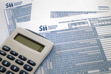 Bir Şili vergi formunun üstündeki hesap makinesi.