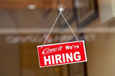 Bir dükkânın cam kapısında asılı kırmızı tabela: 