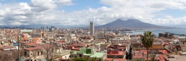 Naples, Italy - March 19 2018: Aerial view of the Castel Nuovo, the Hotel NH Napoli Ambassador, the mercato, the Bourbon royal family mausoleum of the Two Sicilies and the jetty, with behind, the Vesuvius. clipart