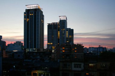 Arka planda Ratchaprarop yolu yakınlarındaki modern apartmanlar ön plandaki eski binaların aksine.