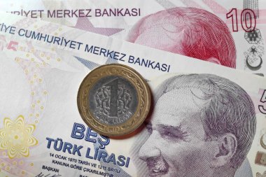 Close-up on a coin on top of a banknote of 5 an 10 Turkish lira (TRY). clipart