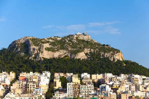 stock image Cityscape of Athens with the Metropolitan Cathedral of Athens, the Church of St Dionysius the Areopagite and the Church of St George on top of Mount Lycabettus.