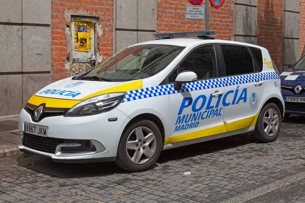 Stock image Madrid, Spain - June 06 2018: A white police car from the Municipal police (Spanish: Policia municipal) parked outside of a police station.