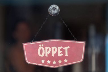 Bir dükkanın vitrinindeki eski moda levhada İsveççe 