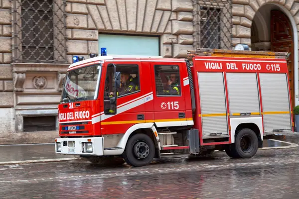 Roma, İtalya - 18 Mart 2018: İtfaiyeciler görev yaptıkları binanın ana girişinden hareket ediyorlar.