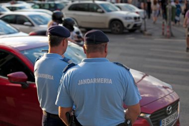 Bükreş, Romanya - 24 Haziran 2018: Jandarma 'dan iki memur Piata de Victoriei' deki kalabalığı izliyor.