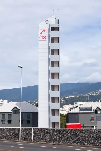 stock image Observation tower of the fire station of Saint Denis de la Reunion arboring the number 18 with the phone in red which is the symbol of the fire fighters in France for decades.