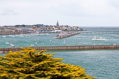 Roscoff, France - July 22 2017: Ferry from Batz Island entering the Port in Roscoff, with behind, the spire of the Eglise Notre-Dame de Croaz Batz. clipart