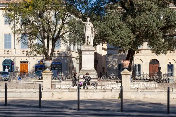 stock image Nimes, France - March 21 2019: The Antonin Square forms a square whose central space is closed by a wrought iron gate with in its center the monumental Carrara marble statue of Emperor Antoninus, sculpted by Auguste Bosc and inaugurated in 1874.