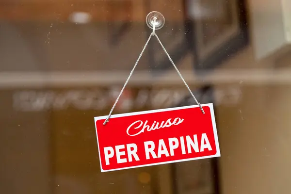 stock image Red sign hanging at the glass door of a shop saying in Italian 