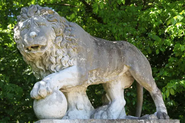 Pençesi küreye yerleştirilmiş bir aslan heykeli Henri Legrand tarafından 17. yüzyılda oyulmuştur. Chantilly Kalesi 'nin karşısında..