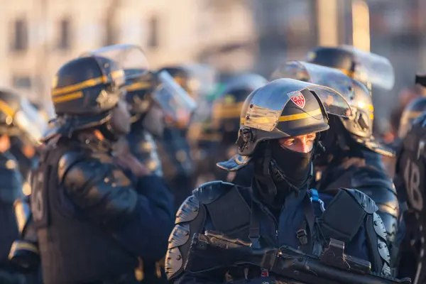 stock image Marseille, France - March 23 2019: CRS officers in riot gear with helmet, balaclava, bulletproof vest and defensive bullet launcher.