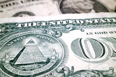 İki tane 1 dolarlık banknotun üzerine yakın plan çekiliyoruz ve dikkatleri Tanrı 'nın Gözü üzerinde..