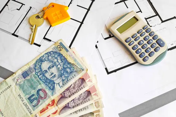 stock image Close-up on some Croatian Kuna (HRK) banknotes, a home key and a calculator on the top of building plans.