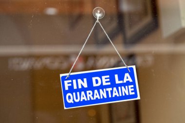 Bir dükkânın cam kapısında asılı mavi tabela Fransızca 