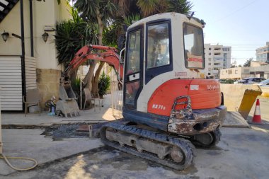 Larnaca, Cyprus - June 4 2024: A Kubota KX71-3 mini-excavator outside a construction site. clipart