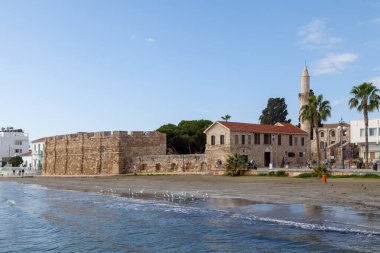 Larnaca, Kıbrıs - 17 Şubat 2024: Larnaca Şatosu ve Akdeniz kıyısındaki Djami Kebir Camii Minaresi