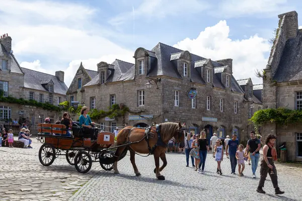 stock image Locronan, France - August 17 2023: Horse-drawn carriage taking tourists through the city center.