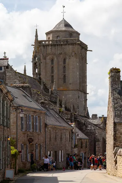 stock image Locronan, France - August 17 2023: Bell tower of the Saint-Ronan's church dwarfing the rest of the town.