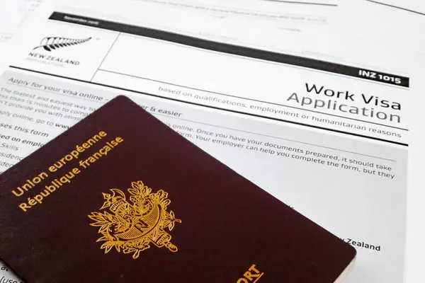 stock image French passport on top of a work visa application form to work in New Zealand.