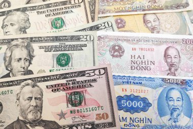 Close-up on a stack of US Dollar and Vietnamese Dong. clipart