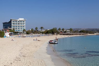 Ayia Napa, Kıbrıs - 15 Kasım 2024: İnsanlar Ayia Napa 'daki Makronissos Sahilinde sıcak havanın son günlerinin tadını çıkarıyorlar.