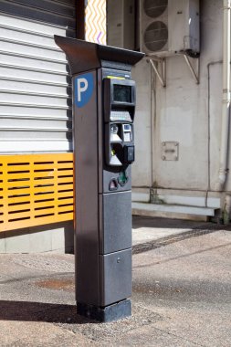 Üstünde güneş paneli olan bir park cezası makinesi..