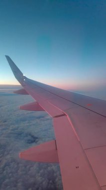 Gün doğumunda bulutların üzerinde uçan uçak..