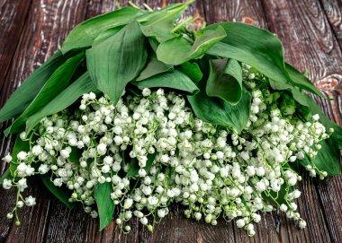 Vadi çiçekleri zambaklarının arka planı. Beyaz bahar kokulu Mayıs çiçekleri ahşap arka planda, üst manzara