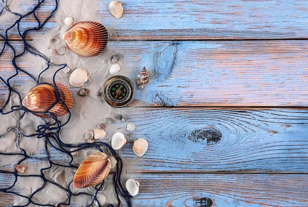 stock image Sea background with seashells, fishing net, sand and compass. Summer vacation at sea concept