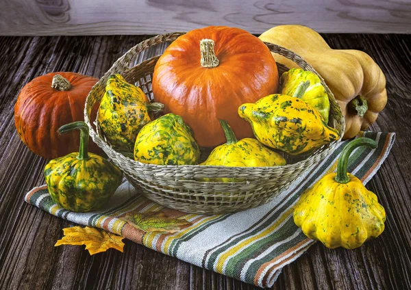 采购产品成熟的黄色和橙色南瓜篮 秋天的叶子 亚麻布条纹餐巾纸在木制的背景 秋天静谧生命 — 图库照片