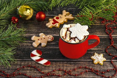 Marşmelovlu kırmızı bardak ve zencefilli kar tanesi, yan görüş. Tahta arka planda zencefilli kurabiyeli Noel kompozisyonu