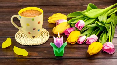 Bahar, beyaz bir benekli kahve, bir buket sarı ve pembe lale çiçekleri ve ahşap arka planda bir mum ile durgun bir hayattır..