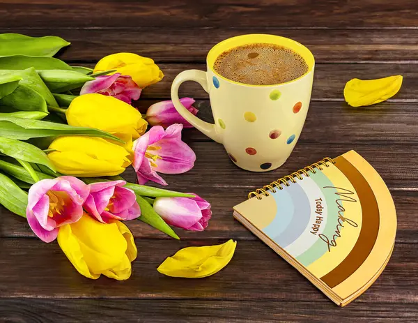 Spring bouquet of yellow and pink tulips, white polka dot cup of coffee, colorful notebook on dark wooden background. Spring still life