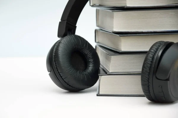 Açık Arkaplanlı Siyah Kulaklıklar Ses Kitapları Veya Modern Eğitim Kavramı — Stok fotoğraf