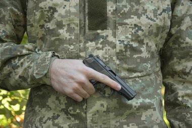 Kharkiv, Ukrayna - 18 Ekim 2022: Askeri kamuflaj pikseli ve Ukrayna bayrağının arka planında kartuşlar bulunan bir Makarov tabancası. Başbakan daha kısa. Ukrayna 'da Savaş.