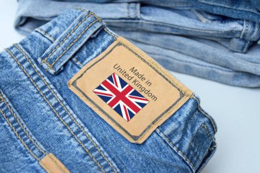 Kot pantolonun, etiketin ve Birleşik Krallık harflerinin ayrıntıları. Satın alma, satma, alışveriş ve modaya uygun modern kıyafetler.
