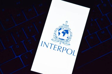 Kharkiv, Ukrayna - 16 Haziran 2022: Ekranda Interpol logosu sergilenen bir akıllı telefon klavyede bulunuyor. Uluslararası Suç Polis Örgütü veya Interpol.