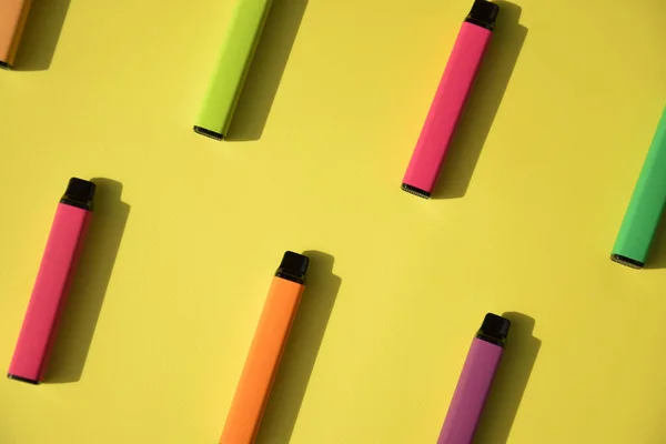 一套五颜六色的一次性电子香烟在明亮的黄色背景上 现代吸烟 蒸气和尼古丁的概念 — 图库照片