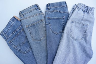 Bir sürü kot pantolon var. Denim geçmişi. Satın alma, satma, alışveriş ve modaya uygun modern kıyafetler.