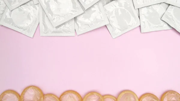 분홍색 배경에는 임신이나 질환에 확률을 줄이기 콘돔을 섹스와 건강의 — 스톡 사진