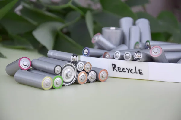 緑の背景にAa電池を使用し 環境や土壌に有害な電池の適切な処分 有害物やリサイクル可能な物を処理するという概念 — ストック写真