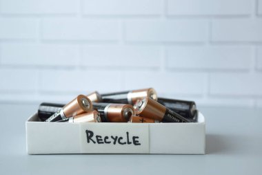 KHARKIV, UKRAINE - 22 Şubat 2022: Kullanılmış AA bataryalar ve çevresel ve toprak zehirli bataryaların mavi arka planda düzgün bir şekilde imha edilmesi. Zararlı ve geri dönüşümlü nesnelerin işlenmesi kavramı.