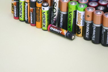 KHARKIV, UKRAINE - 11 Haziran 2022: Kullanılmış AA bataryalar ve yeşil zemin üzerinde çevresel ve toprak toksik bataryaların uygun şekilde imha edilmesi. Zararlı ve geri dönüşümlü nesnelerin işlenmesi kavramı.